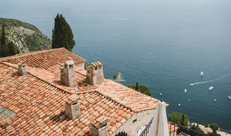renovation-toiture-villa-nice-cote-d-azur Nettoyage de toiture à Nice sur une villa en bord de mer avec tuiles canal traditionnelles.